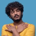 Salud mental masculina. retrato de un joven sereno con los ojos cerrados de pie contra el fondo azul